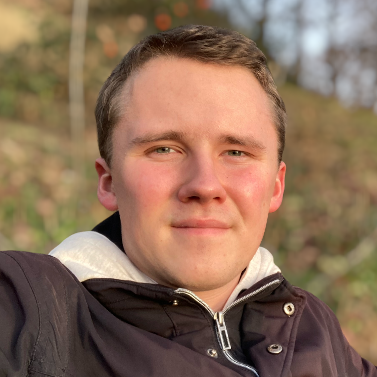 Andreas Hamann in einer braunen Jacke im Wald.