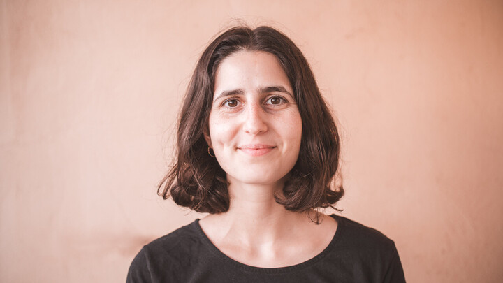 Naomi Bader wearing black top in front of terracotta wall