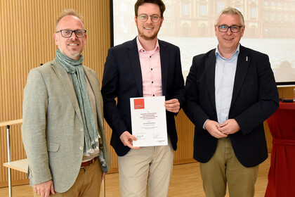 Der Preisträger Jan Schweers (mitte) mit Bildungsbürgermeister Dirk Grunert (links) und Wirtschaftsbürgermeister Thorsten Riehle (rechts).