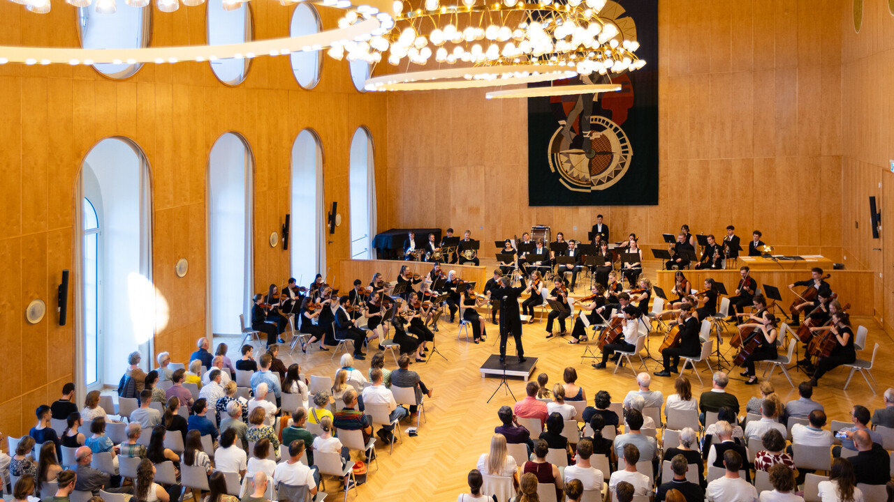 Auftritt des Uniorchesters in der Aula der Universität Mannheim. Publikum blickt nach vorne während das Orchester spielt