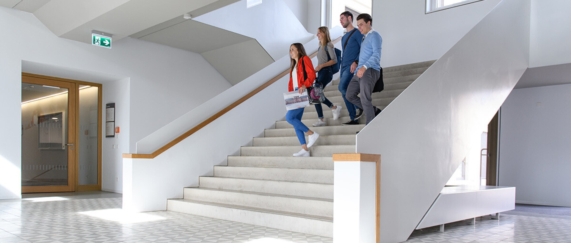Vier Studierende laufen die Treppe des B6-Gebäudes runter.