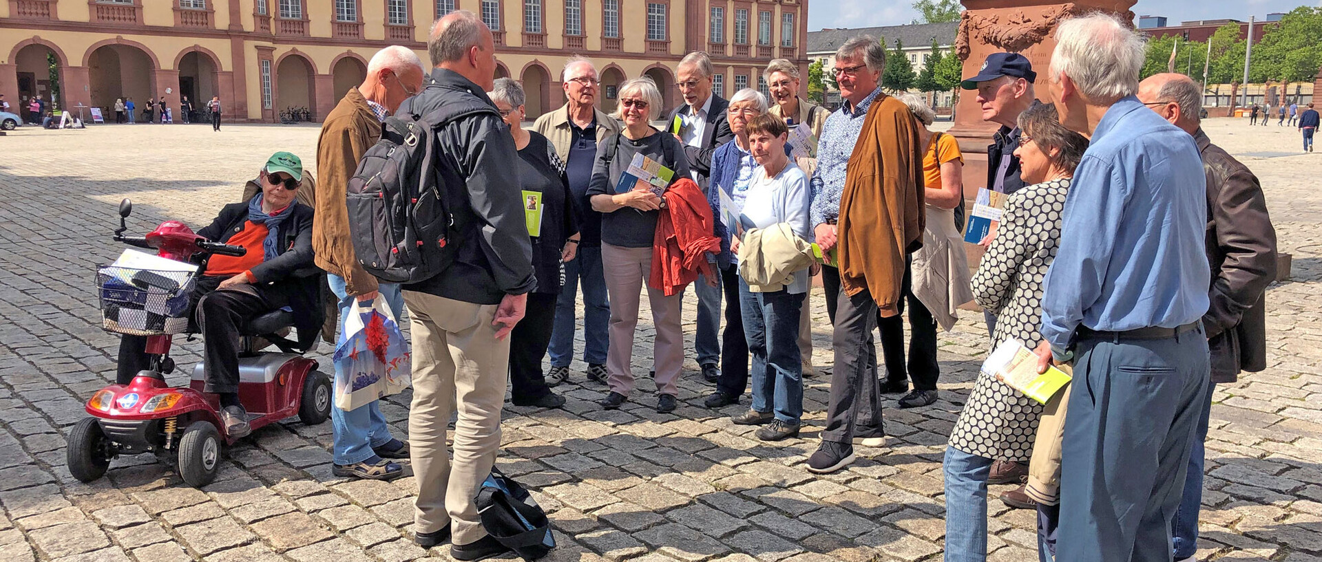 Eine Gruppe von Menschen steht auf dem Ehrenhof