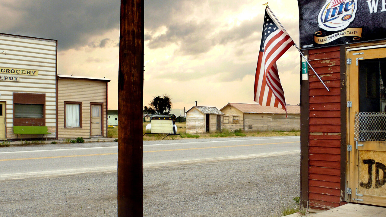 Alte Holzbauten. Links auf der anderen Straßenseite: Gebäude mit Aufschrift