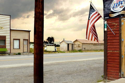 Alte Holzbauten. Links auf der anderen Straßenseite: Gebäude mit Aufschrift 