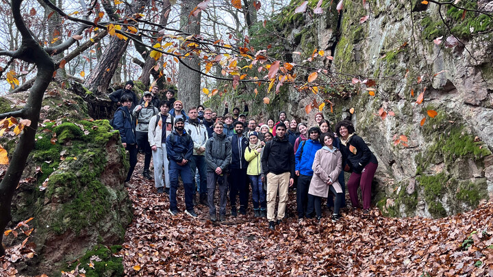 Eine Wandergruppe im Wald neben großen Felsen.