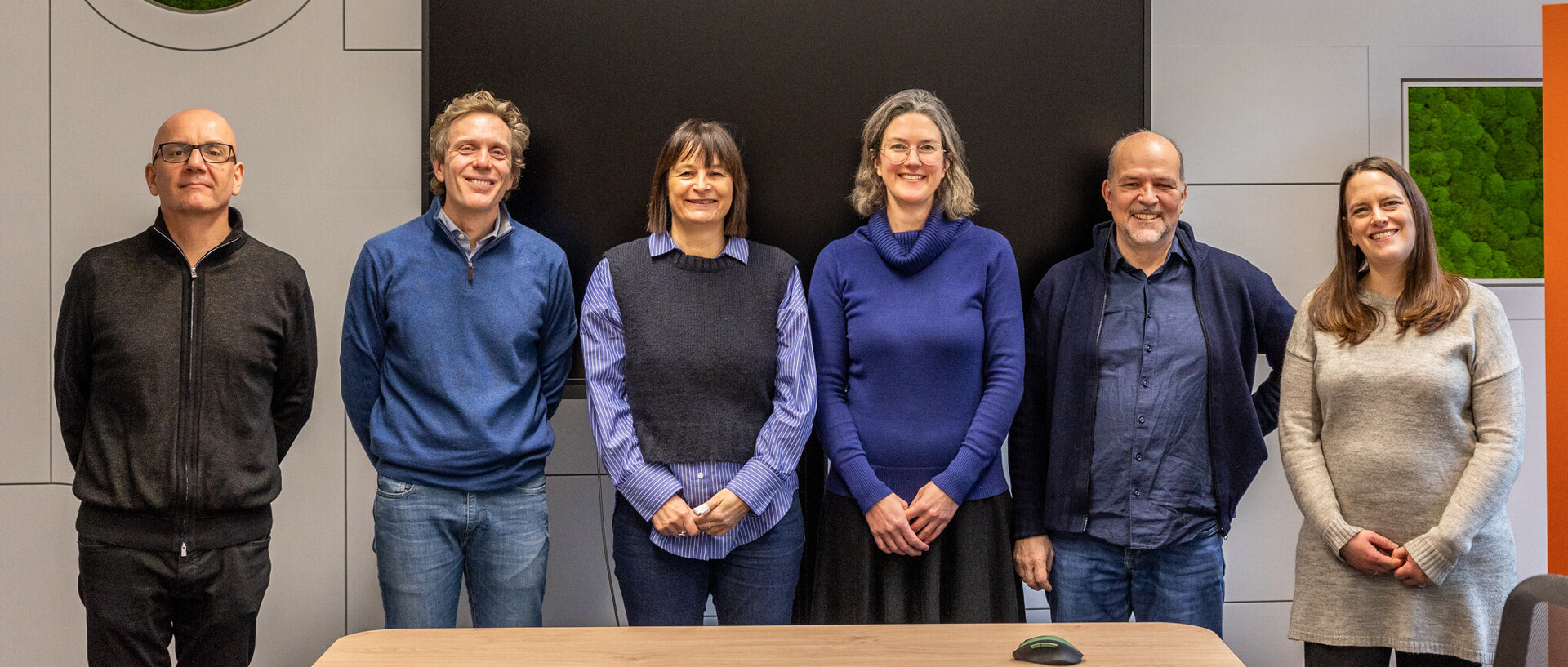 Die sechs Fellows der ersten Kohorte stehen in einer Reihe in einem CAS Raum. Sie machen alle ein fröhliches Gesicht.