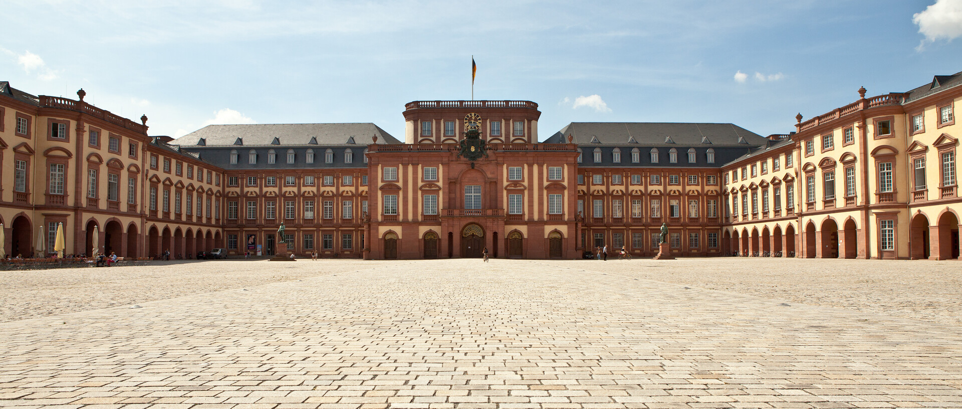Das Mannheimer Barockschloss und der Ehrenhof unter blauem Himmel.