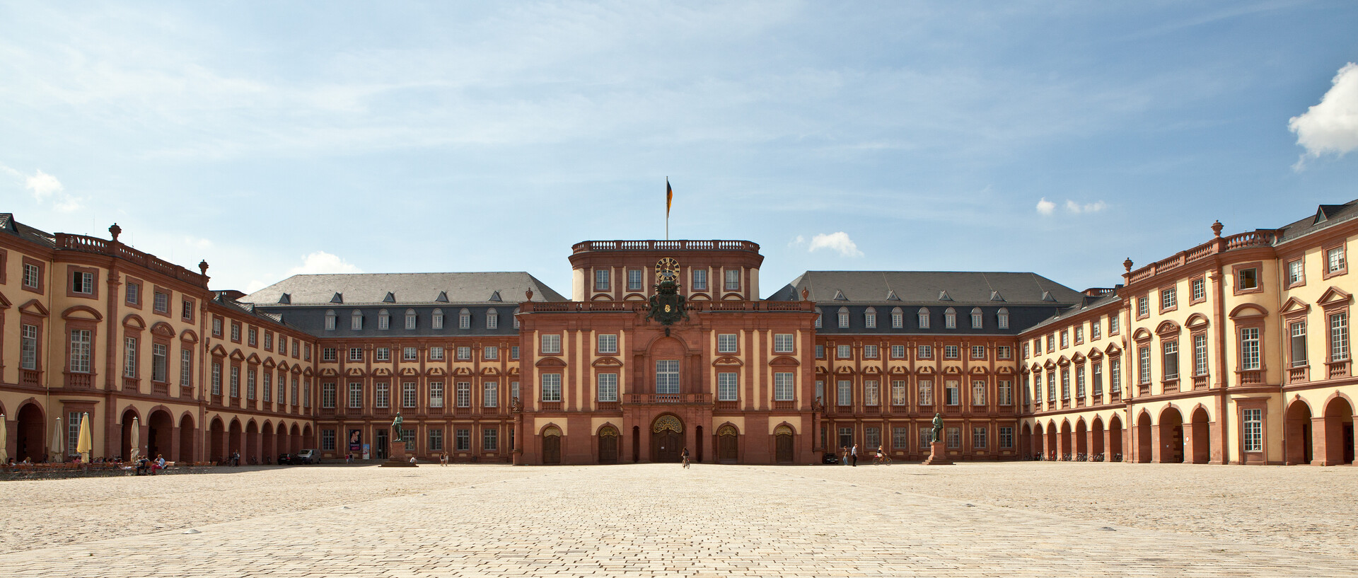 Das Mannheimer Barockschloss und der Ehrenhof unter blauem Himmel.