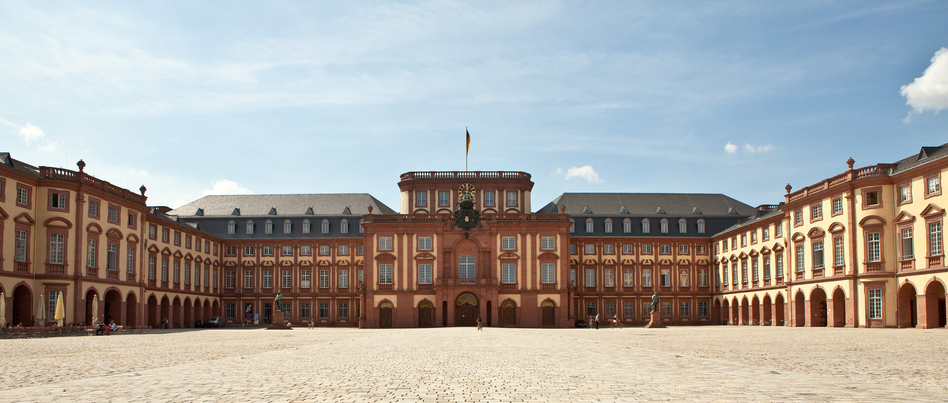 Das Mannheimer Barockschloss und der Ehrenhof unter blauem Himmel.