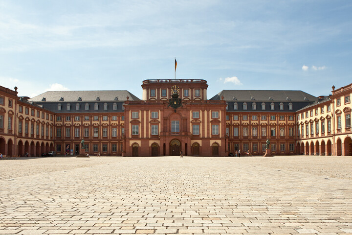 Das Mannheimer Barockschloss und der Ehrenhof unter blauem Himmel.