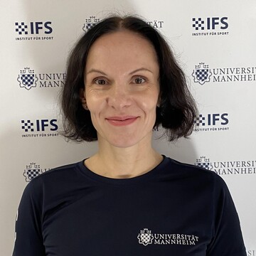 Tetyana Ussar hat kurze dunkelbraune Haare. Sie trägt ein dunkelblaues T-Shirt mit der Aufschrift "Universität Mannheim".