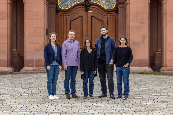 Group photo of the GIP team. 5 people in front of Mannheim Castle.