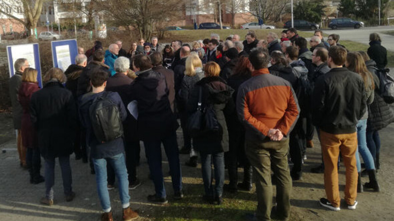 Rektor Prof. Dr. Thomas Puhl präsentiert die Pläne zur Bebauung des Friedrichparks. Um ihn herum sind Zuschauende.