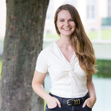 Lara Reimer. Sie lächelt freundlich, trägt eine weiße Bluse und offenes Haar.