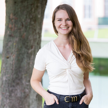 Lara Reimer. Sie lächelt freundlich, trägt eine weiße Bluse und offenes Haar.