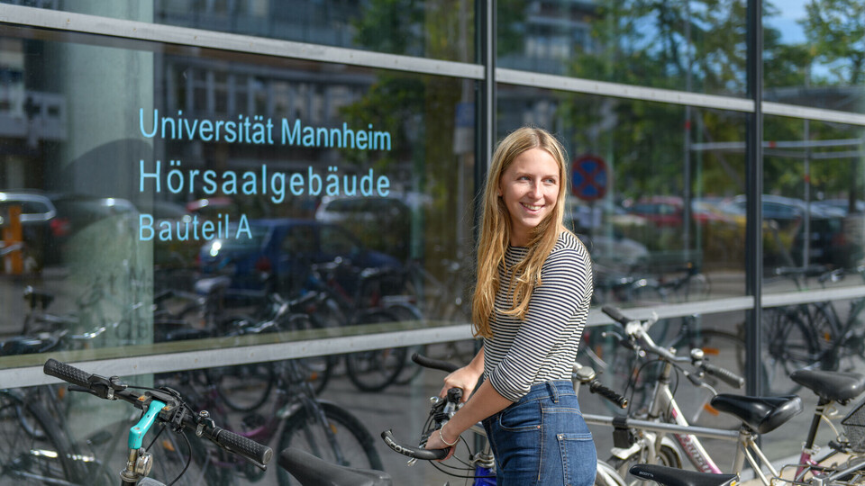 Eine Studentin schließt ihr Rad auf. 