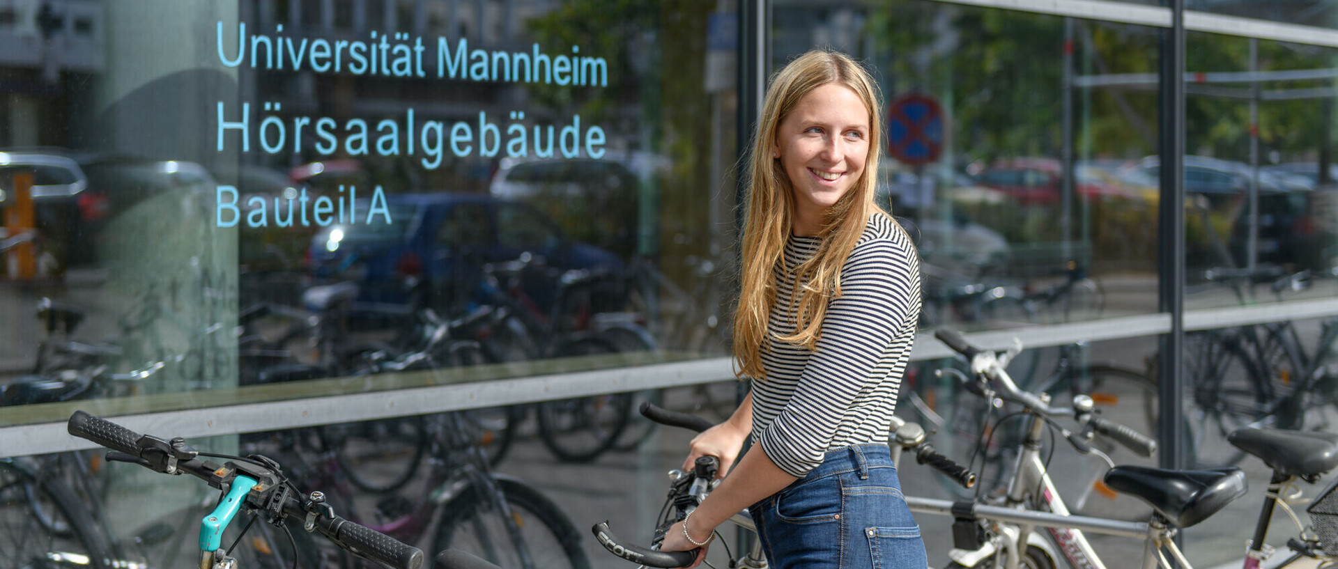 Eine Studentin schließt ihr Rad auf. 