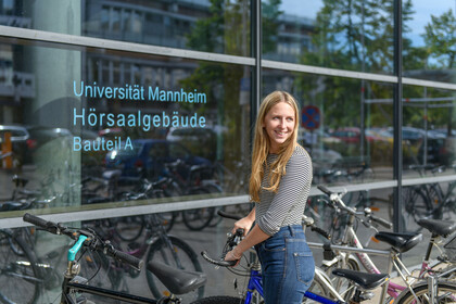 Eine Studentin schließt ihr Rad auf.