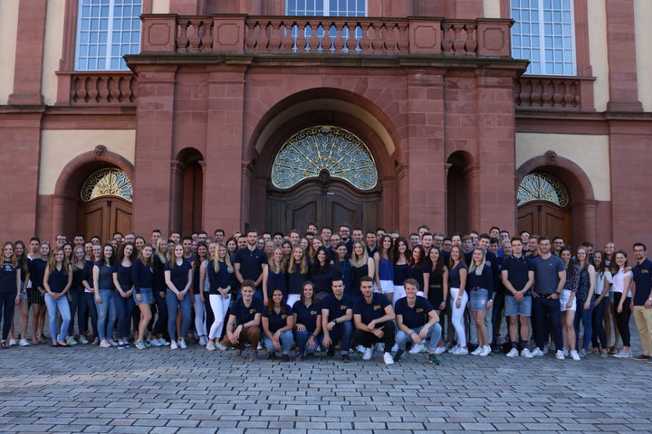Die Studierenden der Fachschaft Betriebswirtschaftslehre stehen in dunkelblauen Polohemden im Ehrenhof.