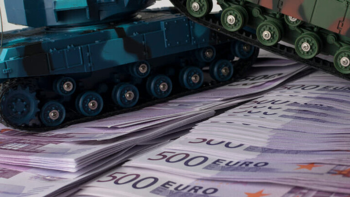 Ein Spielzeugpanzer steht auf 500-Euro-Scheinen