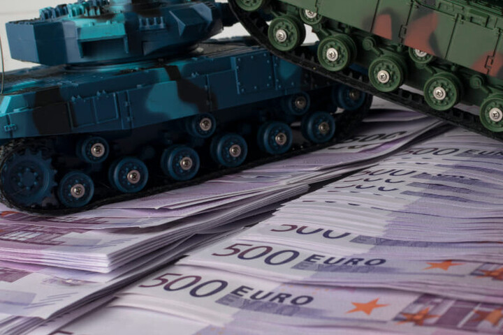 Ein Spielzeugpanzer steht auf 500-Euro-Scheinen