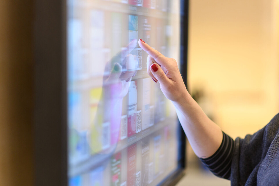 Eine Frau tippt auf einen Bildschirm.