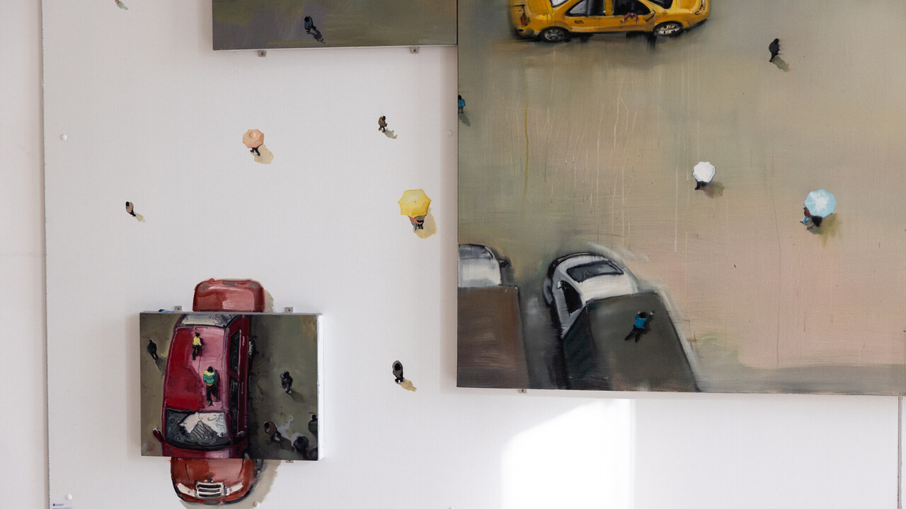 Gemälde von Autos mit Miniaturfiguren, das sich von der Leinwand auf die Wand fortsetzt.