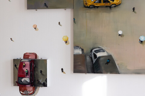 Gemälde von Autos mit Miniaturfiguren, das sich von der Leinwand auf die Wand fortsetzt.