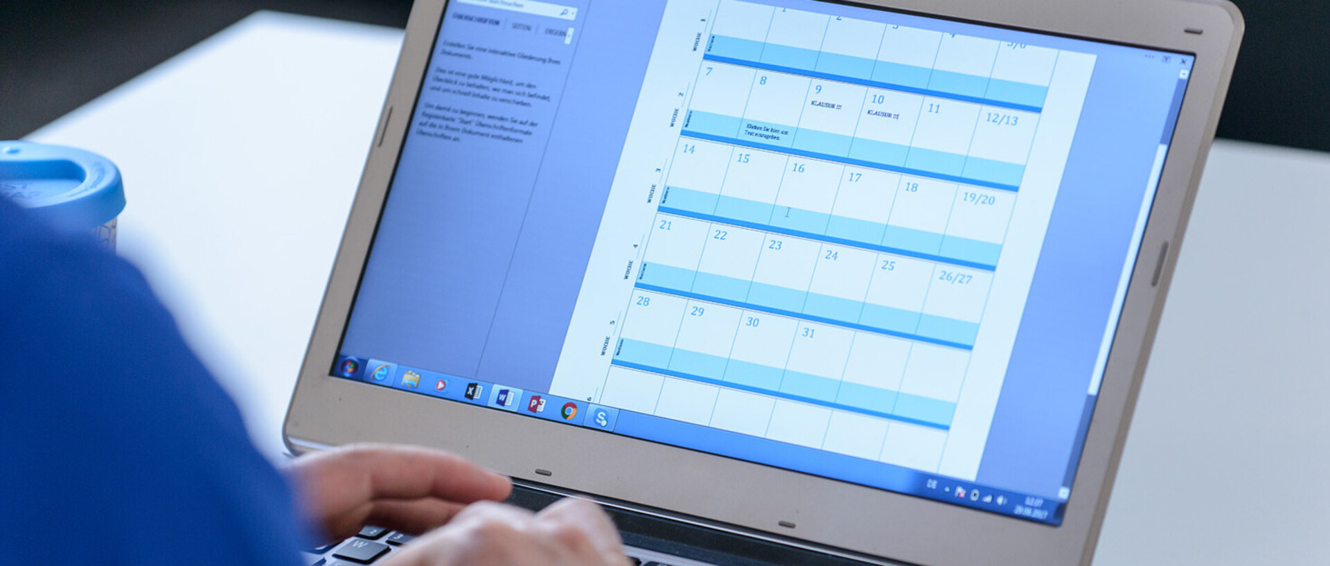 Ein Student trägt auf seinem Laptop Termine in den Kalender ein.