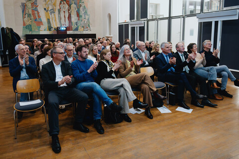 Das Foto zeigt das Publikum in einem nahezu vollbesetzten Festsaal
