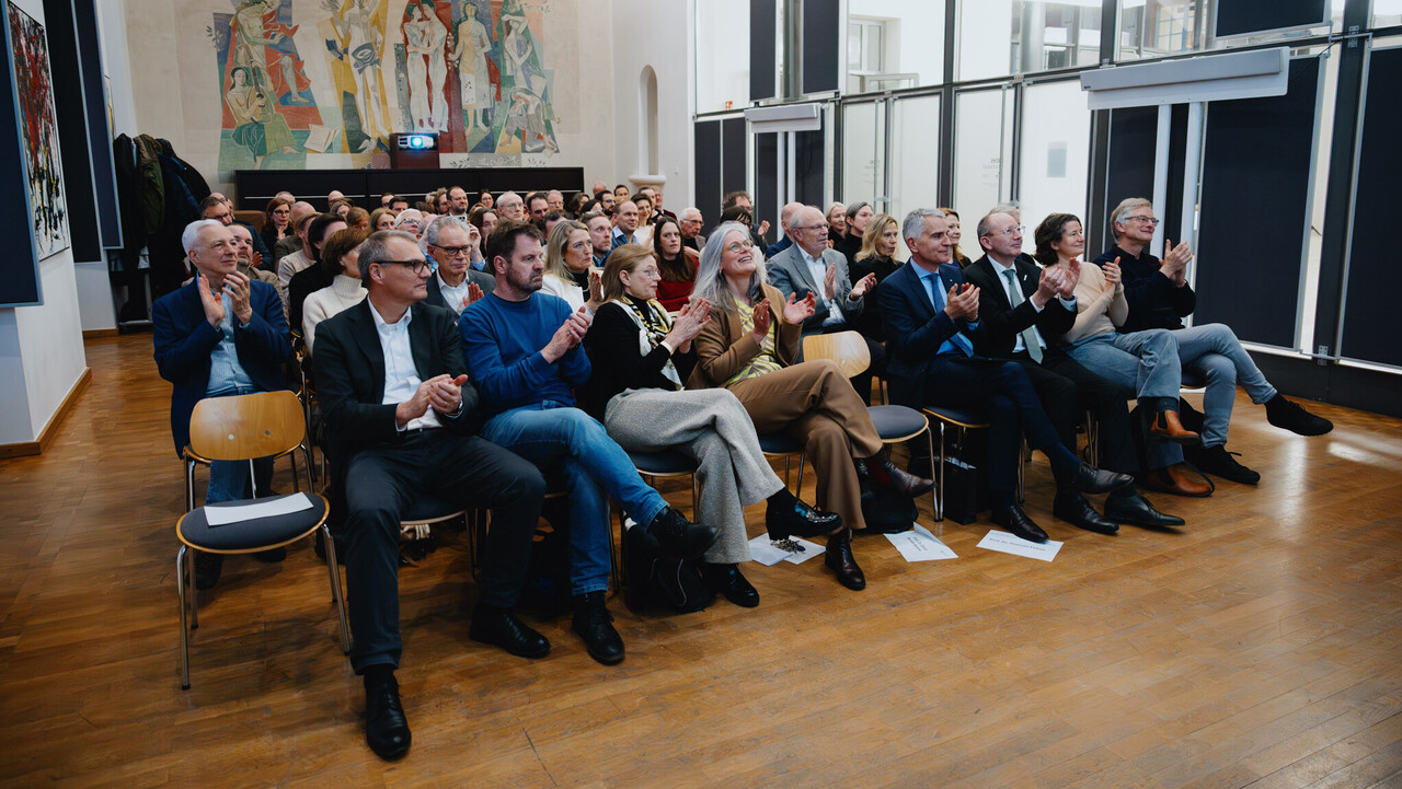 Das Foto zeigt das Publikum in einem nahezu vollbesetzten Festsaal