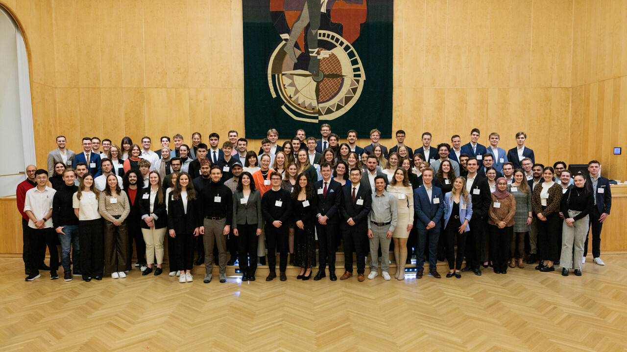 Fast 100 Studierende stehen zusammen und posieren für ein Foto.