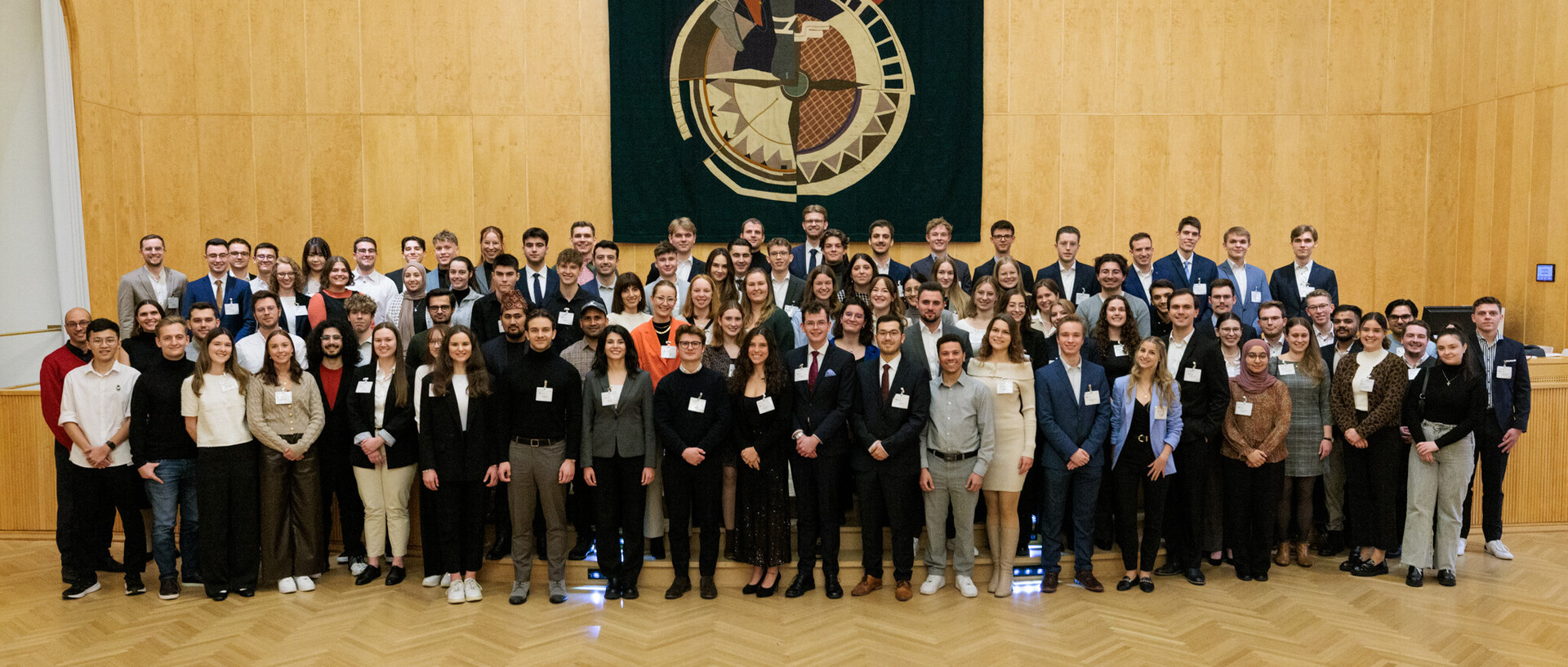 Fast 100 Studierende stehen zusammen und posieren für ein Foto.