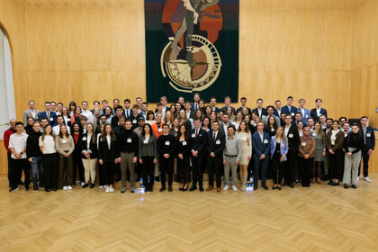 Fast 100 Studierende stehen zusammen und posieren für ein Foto.