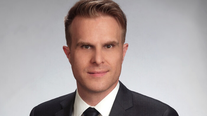 Prof. Stahl has short hair and wears a suit and tie.