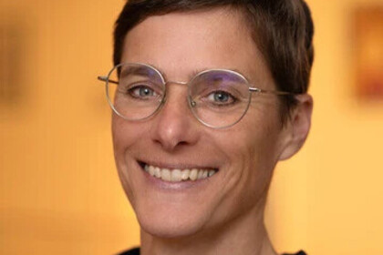 Portrait von Tina In-Albon. Sie trägt kurze Haare, eine Brille und lächelt in die Kamera.