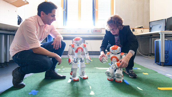 Zwei Personen mit zwei Robotern