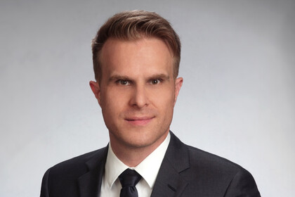 Portraitfoto von Florian Stahl mit grauem Hintergrund