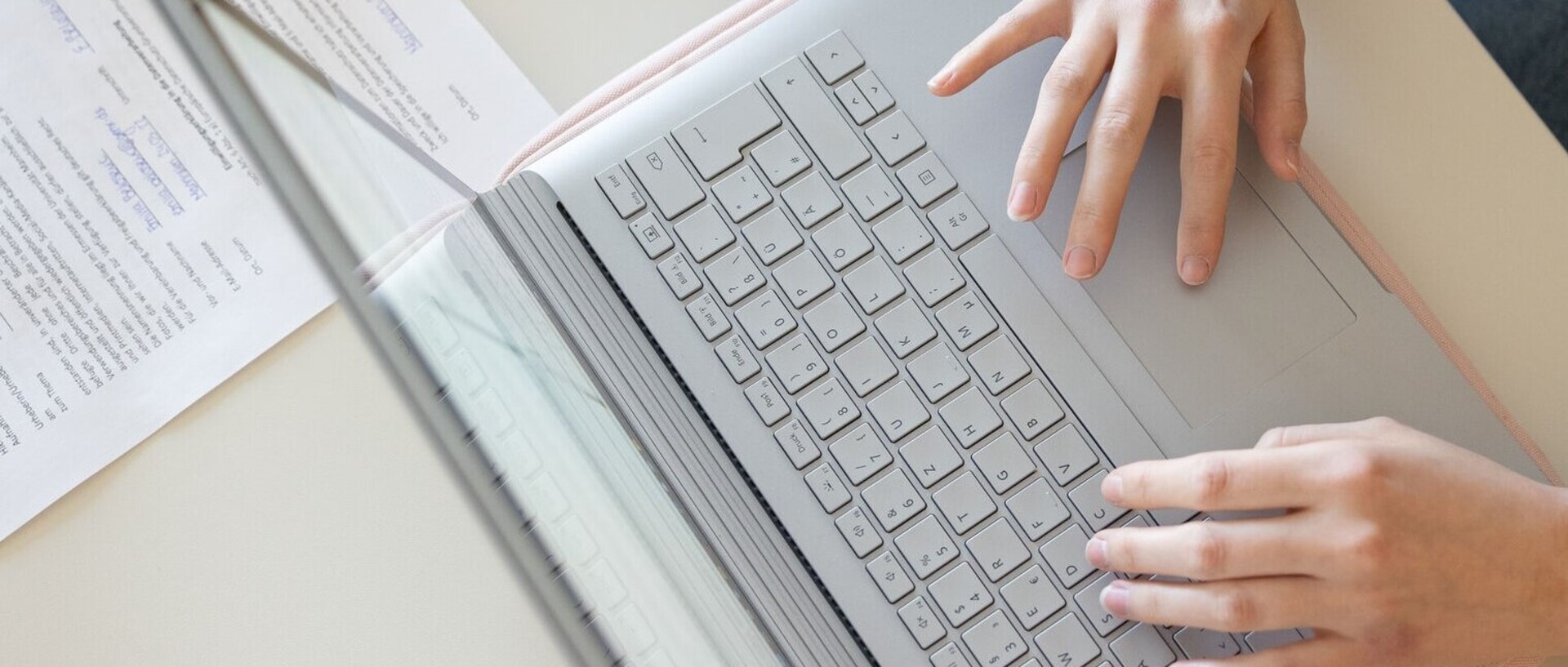 Hände einer Person, die am Laptop arbeitet. Blick von oben auf die Hände und die Tastatur