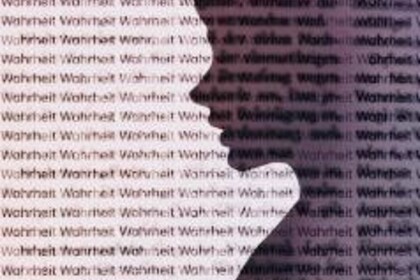 Die transparente Silhouette eines Kopfes vor dem Hintergrund mit dem fortlaufenden Schriftzug "Wahrheit"