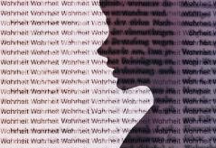 Die transparente Silhouette eines Kopfes vor dem Hintergrund mit dem fortlaufenden Schriftzug "Wahrheit"