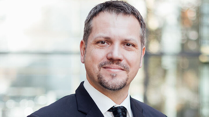 Frederik Armknecht hat dunkle kurze Haare und einen Bart um Kinn und Mund.