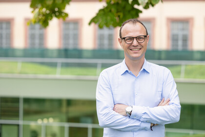 Porträtbild von Professor Moritz Kuhn. Er trägt ein Hemd und eine Brille.