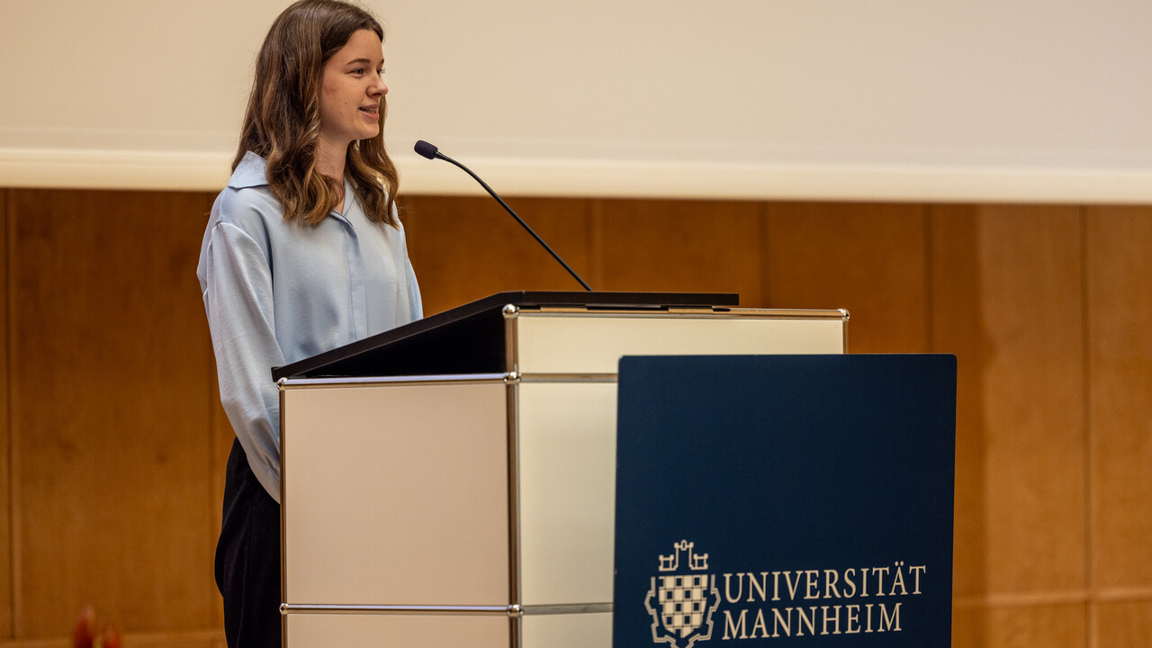 Eine Stipendiatin steht an einem Rednerpult und spricht