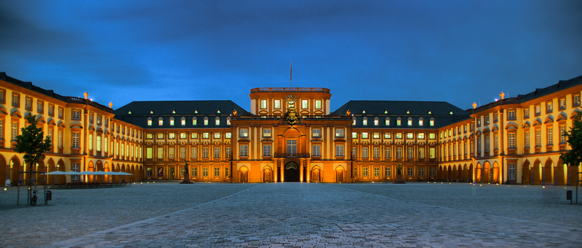 Das Schloss Mannheim wird bei Nacht orange angeleuchtet.
