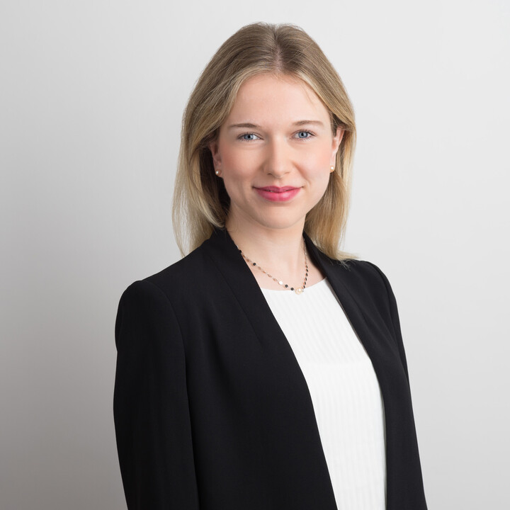 Verena Eppler hat blonde glatte Haare und trägt eine weiße Bluse mit einem schwarzen Blazer sowie einem Goldkettchen.