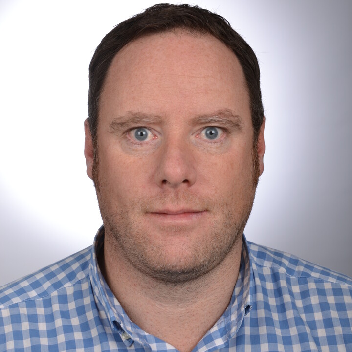 Portraitfoto eines Mannes mit weiß-blau kariertem Hemd