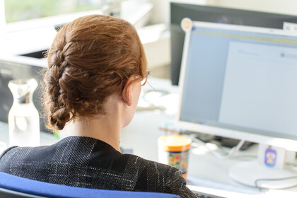 Eine Frau sitzt vor einem Computer.