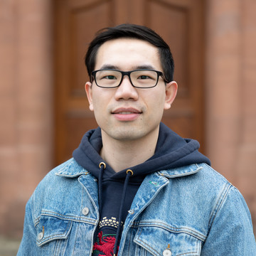 Youpeng Zhang. Er trägt eine Jeansjacke über einen dunkelblauen Pullover.