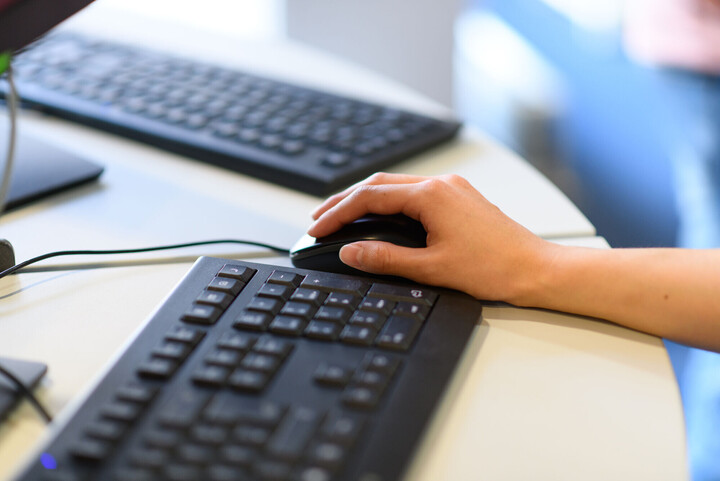 Hände einer Person, die am Laptop arbeitet